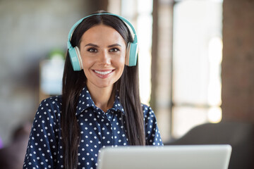 Portrait of young attractive beautiful smiling cheerful good mood businesswoman in headphones at...