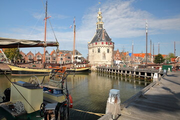 Fototapeta na wymiar The harbor (Binnenhaven) of Hoorn, West Friesland, Netherlands, with the Hoofdtoren (The Head Tower) and old wooden sailing boats
