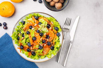 Fresh salad with blueberries, tangerines, carrots and walnuts.