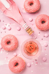 Rose wine or cocktail with pink donuts on pink background