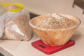 man weighs malt for brewing beer on scale