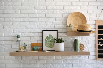 Shelves with decorative elements on white brick wall. Interior design