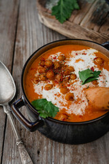 roasted pepper soup with chickpeas, cream and bread crumbs in blue bowls on wooden table, seasonal eating, rustic style