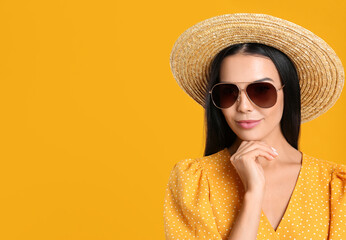 Beautiful woman wearing sunglasses on yellow background. Space for text