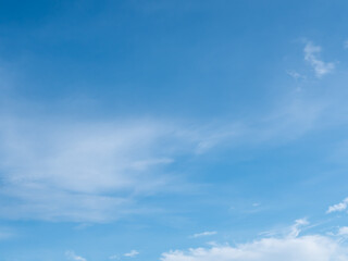 Blue sky background with white clouds on bright summer day.