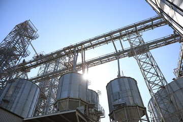 Modern granaries for storing cereal grains against blue sky, low angle view