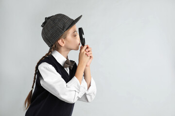 Cute little detective with magnifying glass on grey background. Space for text