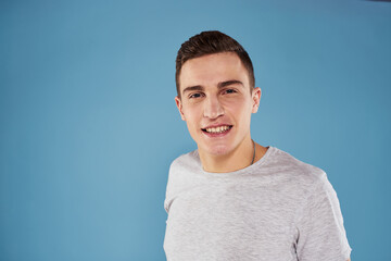 cute emotional man in white t-shirt gesture with hands blue background