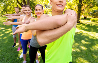 fitness, sport and healthy lifestyle concept - group of happy people exercising with trainer at...