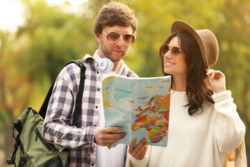 Naklejka premium Couple of travelers with map on city street