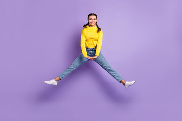 Fototapeta na wymiar Photo of shiny sweet young woman braids wear yellow pullover jumping high isolated purple color background