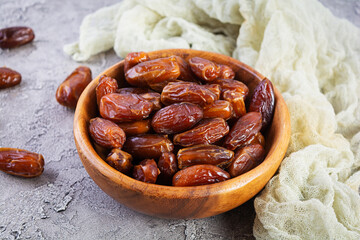 Dried date fruit in bowl on wooden background. Delicious dates fruit