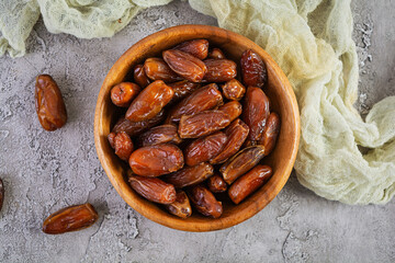 Dried date fruit in bowl on wooden background. Delicious dates fruit