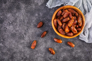 Dried date fruit in bowl on wooden background. Delicious dates fruit. Top view