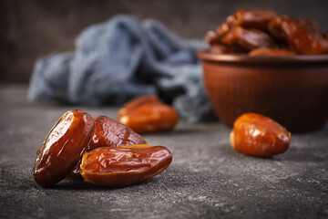 Dried date fruit in bowl on wooden background. Delicious dates fruit