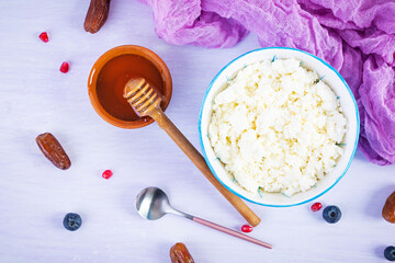 Cottage cheese with honey and berries on pink background. Light vegetarian breakfast. Top view