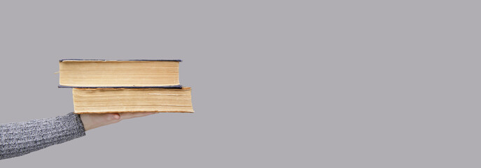 stack of old books in the palm of an invisible person. Banner.High quality photo