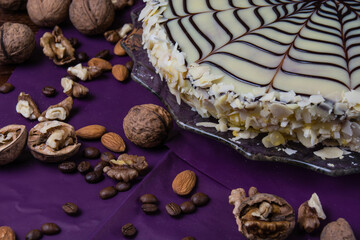 Delicious cake with nuts, almonds, black and white chocolate on a dark background side view copy space, close up