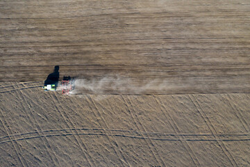 A farmer in a tractor prepares land with a sowing cultivator as part of pre-sowing work at the...