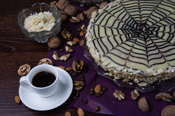 Delicious esterhazy cake with nuts, almonds, black and white chocolate and a cup of coffee on a dark background top view copy space, close up