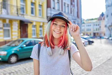 Portrait of fashionable smiling hipster teenage girl with colored dyed hair in black cap