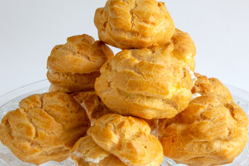 Eclairs on glass plate on a whight background. eclairs with cream.