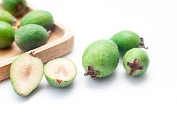 Fresh ripe feijoa on wooden plate. Tropical fruit. Group of ripe feijoa fruits.