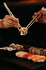 Close-up, couple hands eating sushi food with chopsticks © alexblackphoto