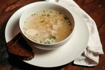Chicken broth with egg and pieces of meat