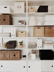 Modern home office cabinet interior design concept. White storage shelves rack with rattan boxes,...