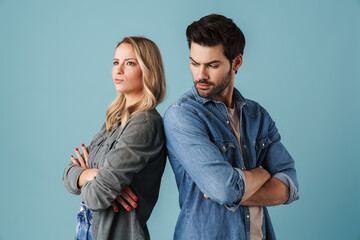 Young caucasian displeased man and woman standing back to back