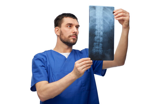 medicine, radiology and healthcare concept - doctor or male nurse in blue uniform looking at x-ray scan image over white background