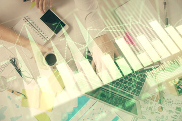 Multi exposure of man's hands typing over computer keyboard and forex graph hologram drawing. Top view. Financial markets concept.