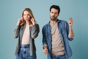 Joyful man singing and dancing while his girlfriend plugging her ears