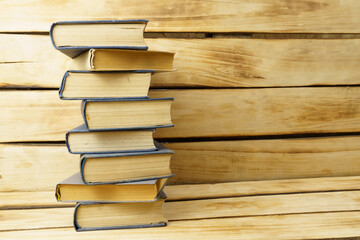 Stack of old books on wood background with copy space.
