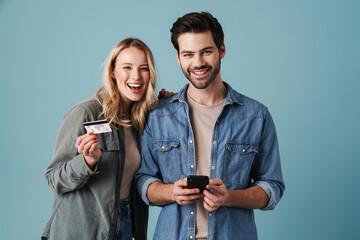 Young caucasian man and woman using credit card and cellphone