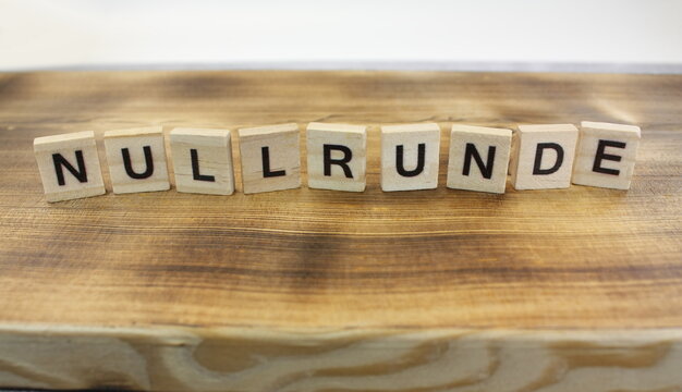 H&ouml;lzerne Textbausteine mit dem Titel "NULLRUNDE" auf einem geflammten Brett