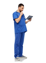 medicine, healthcare and technology concept - doctor or male nurse in blue uniform with stethoscope using tablet pc computer over white background