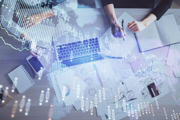 Double exposure of woman hands working on computer and forex graph hologram drawing. Top View. Financial analysis concept.