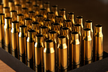 Cases in a wooden stand, blurred background, preparation for reloading, soft focus