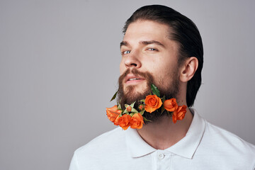 Elegant man in a white shirt flowers in a beard decoration emotions studio light background