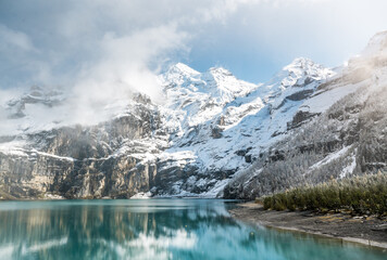 early winter with first snow at mountain lake Oeschinensee