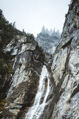 Fototapeta na wymiar waterfall at lake Oeschinensee on a cloudy autumn day