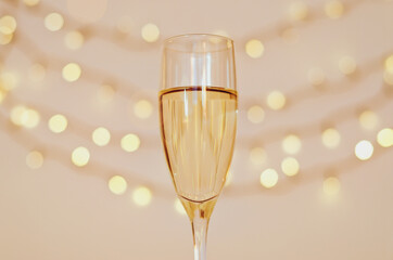 Glass of wine with bokeh background close up. Flat lay. New Year, Christmas mood. Greeting card. Party and holiday celebration concept.