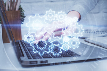 Double exposure of woman hands typing on computer and business theme hologram drawing. Success concept.