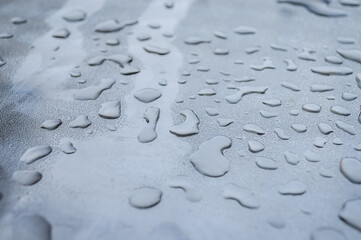 Close up view of water rain drops on a metal surface