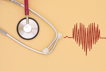 stethoscope on beige background with cardiogram. Medical and healthcare concept.