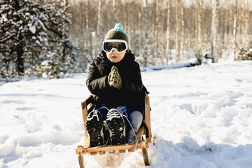 dziecko podczas zimowej zabawy na śniegu na sankach - obrazy, fototapety, plakaty