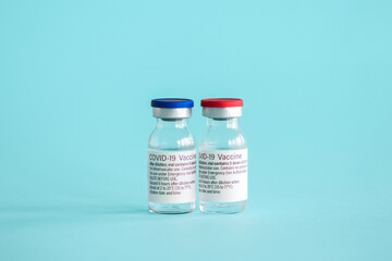 Ampoules with a vaccine against coronavirus infection close-up on a light blue background