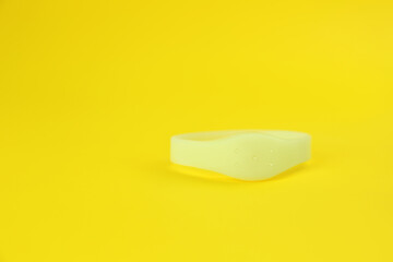 Insect repellent wrist band on yellow background